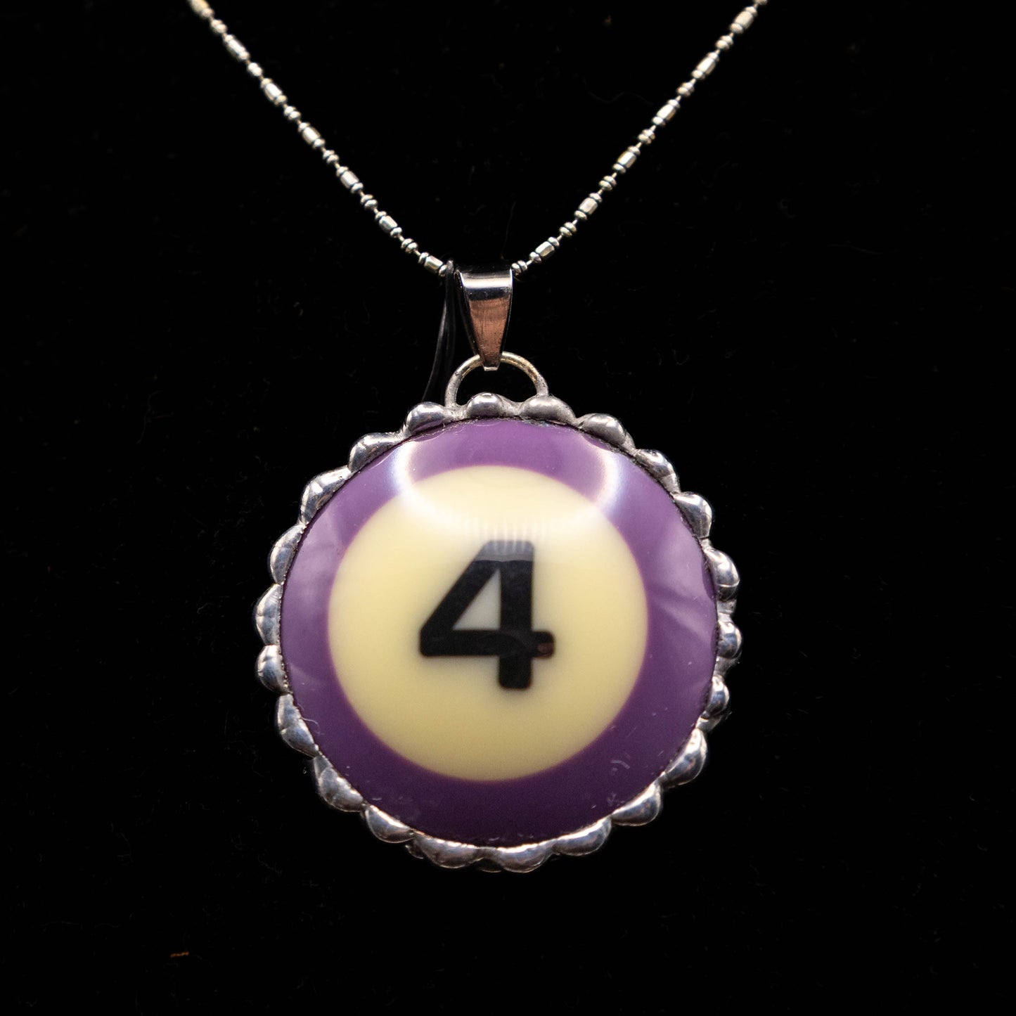Necklace with a purple and white billiard ball pendant featuring the number 4 on a black background.
